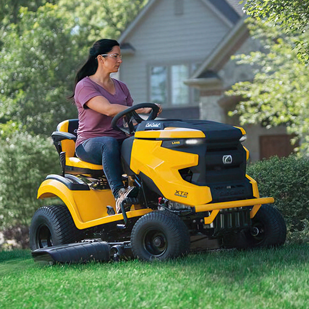 A woman driving a Cub Cadet Enduro XT2 LX 46 K ride-on mower with 24HP Kawasaki engine, 46-inch fabricated deck and diff lock, suited to properties up to 5 acres. Talk to the team at Mower City Albury. 