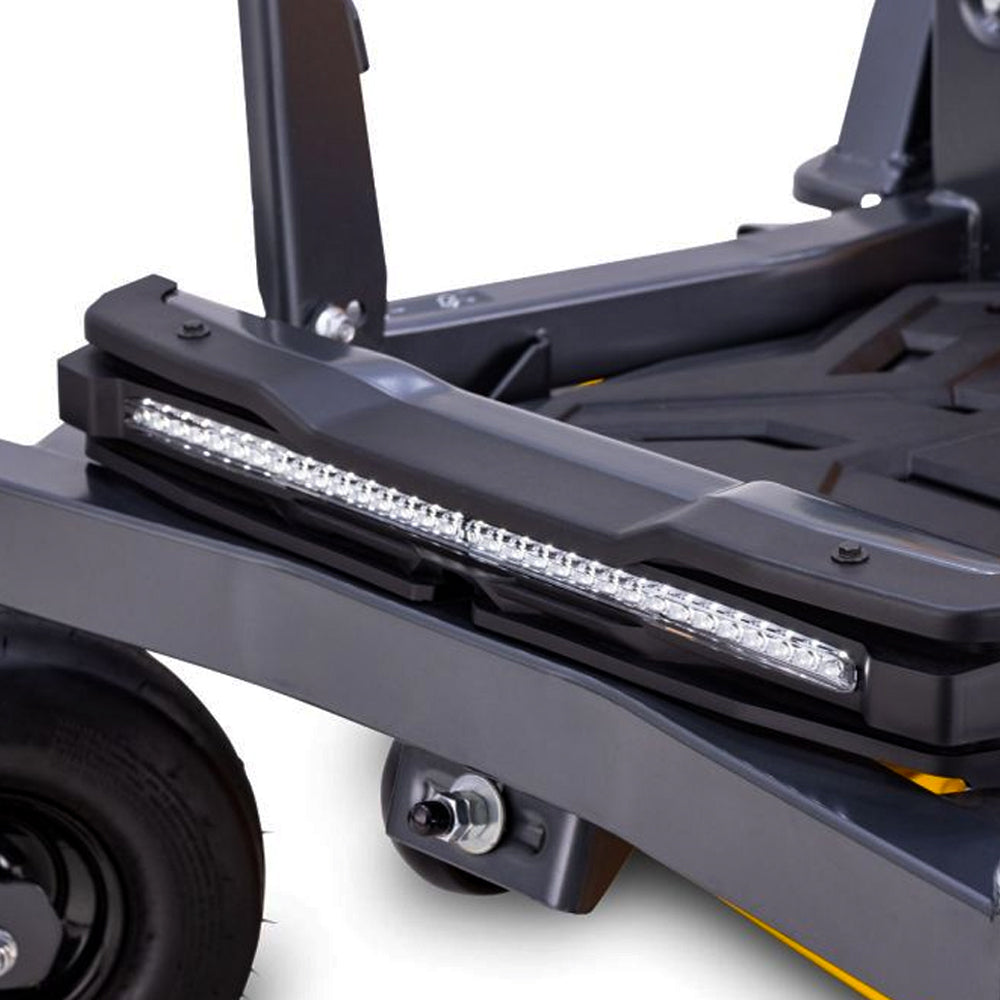 Cub Cadet Ultima Z2 46 zero-turn mower. Close-up of a black metal utility cart or trailer frame with a long rectangular LED light bar mounted across the side, a black wheel, and a small yellow accent strip for larger lawns and blocks up to four acres. Available at Mower City Albury.